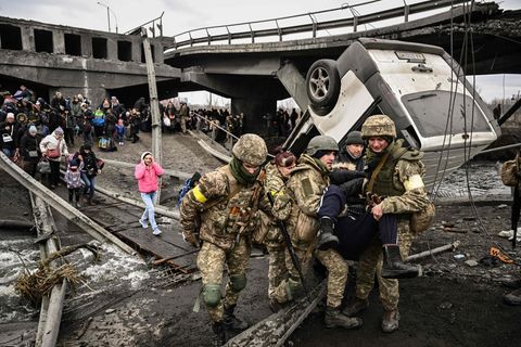 Menschen überqueren zerstörte Brücke bei Irpin