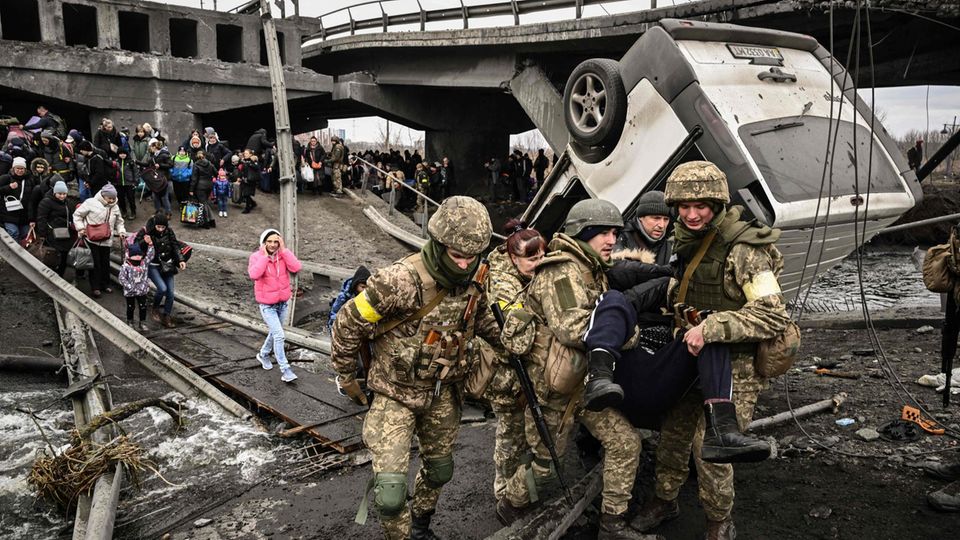 Menschen überqueren zerstörte Brücke bei Irpin