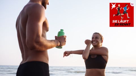 Sport im Urlaub: Ein Mann und eine Frau dehnen sich am Strand