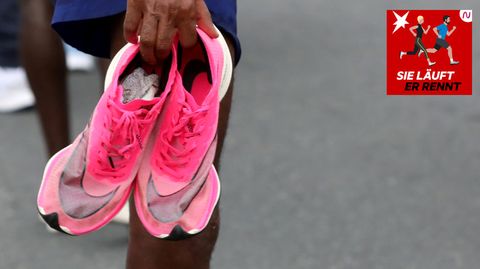 Ein Läufer hält ein paar Schuhe in der Hand