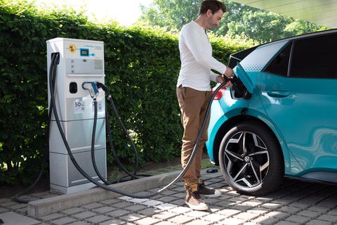 Ein Mann schließt ein Elektroauto an einer Ladesäule an
