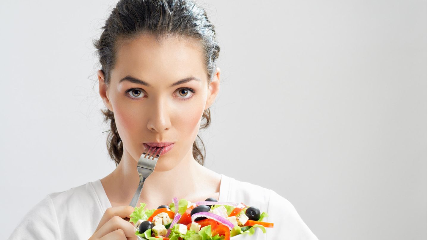 Ernährung: Eine Frau hält eine Schüssel Salat in der Hand
