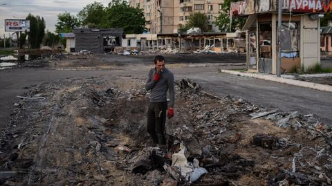 Ein Mann sucht in einem beschossenen Viertel von Charkiw in der Ostukraine nach Metallschrott (Archivbild)