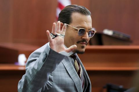 Johnny Depp, Schauspieler aus den USA, winkt während er den Gerichtssaal des Fairfax County Circuit Courthouse verlässt