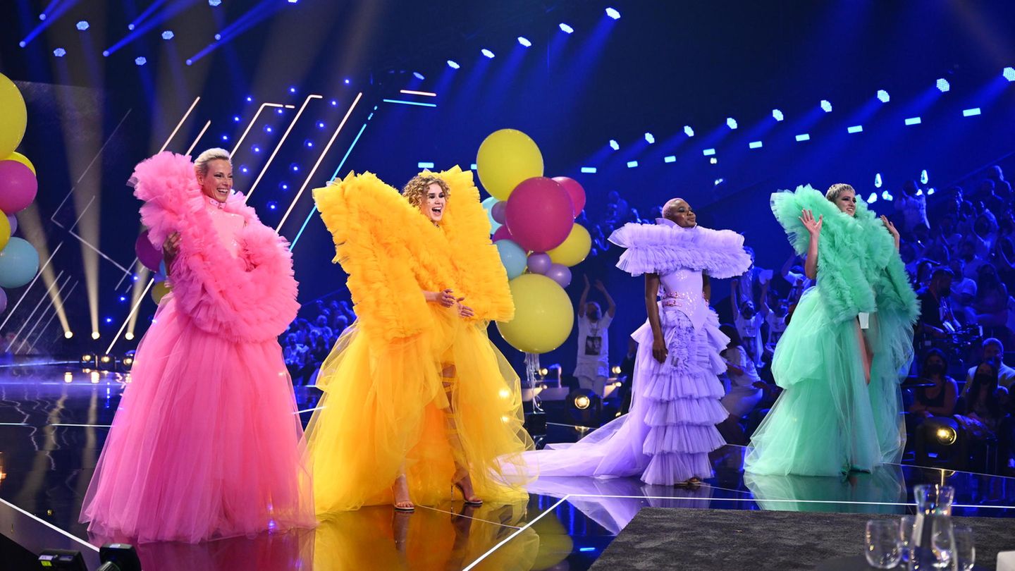 The GNTM candidates Martina, Luca, Noëlla and Lou-Anne are on stage in colorful clothes.