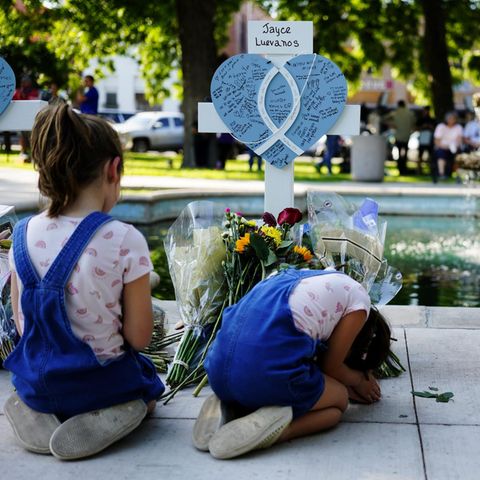 Kinder knien vor Kreuzen mit Herzen