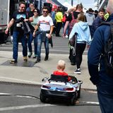 Dieser junge BMW-Fahrer umrundet mit seinem elektrischen Wagen das Fahrerlager.