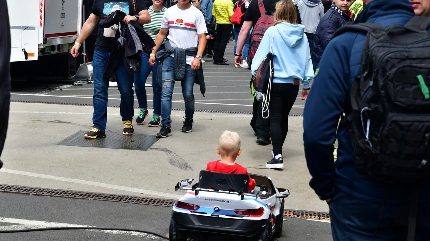 Dieser junge BMW-Fahrer umrundet mit seinem elektrischen Wagen das Fahrerlager.