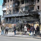 Menschen stehen an einer Bushaltestelle