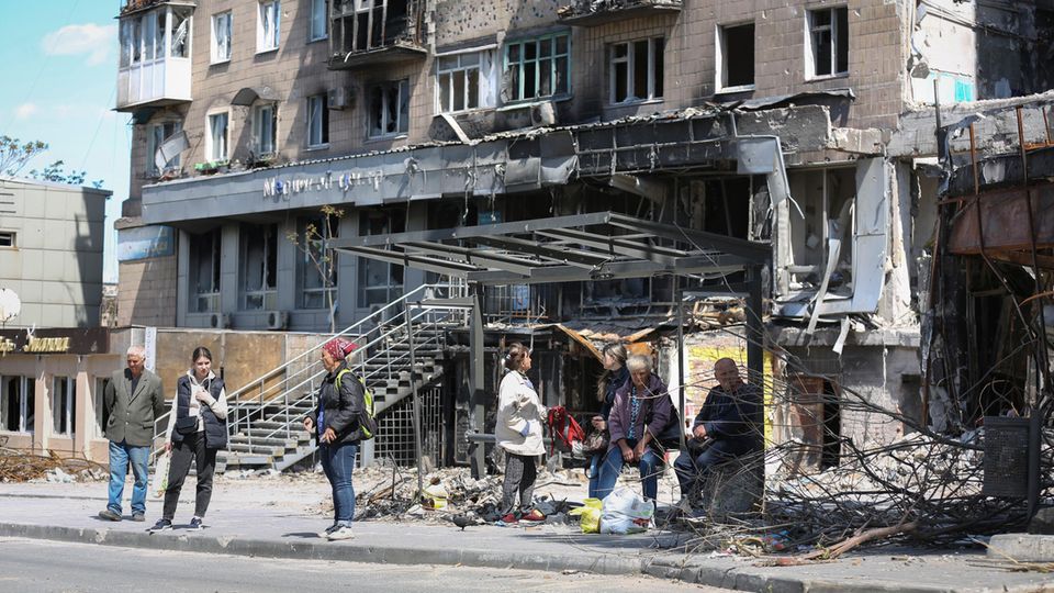 Menschen stehen an einer Bushaltestelle