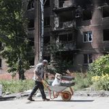 Ein Mann transportiert Habseligkeiten in einer Schubkarre