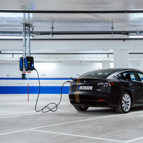 Ein Auto ist mit einem Kabel an eine Ladestation angeschlossen