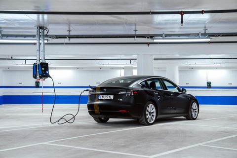 Ein Auto ist mit einem Kabel an eine Ladestation angeschlossen