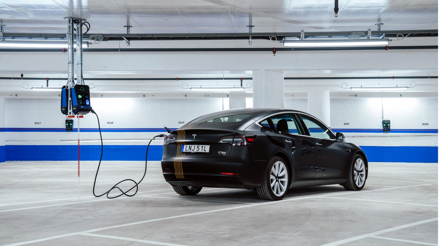 Elektroauto Stockholm Ladestation Parkhaus Elektromobilität Ein Auto ist mit einem Kabel an eine Ladestation angeschlossen