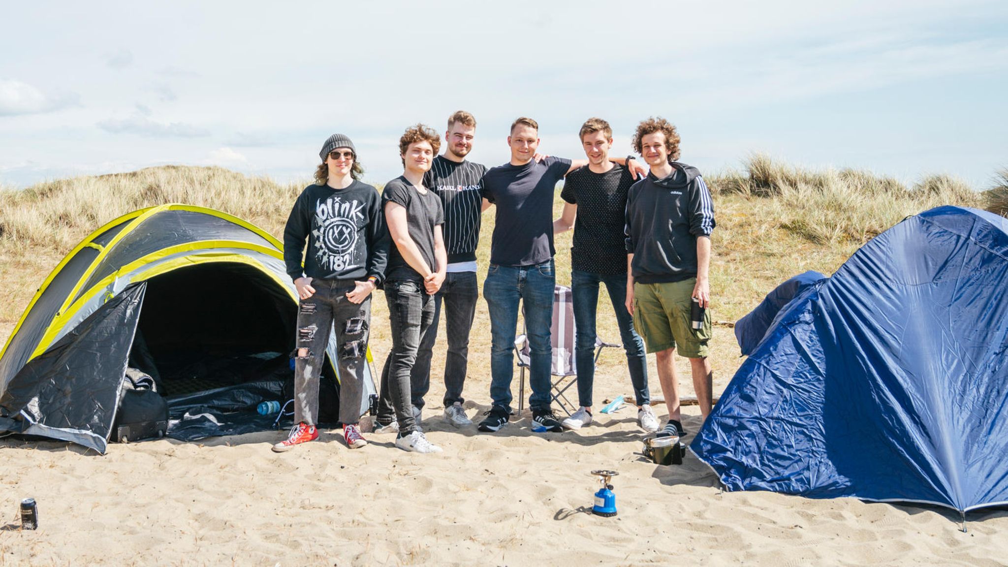 Sechs Jungs vor ihren zwei Zelten in den Dünen