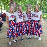 Dass diese vier Damen Queen-Fans sind, ist nicht zu übersehen: Mit Masken, Flaggen und Röcken in den Farben des Vereinigten Königreichs haben sie sich für die "Trooping the Colour"-Parade ausgestattet.