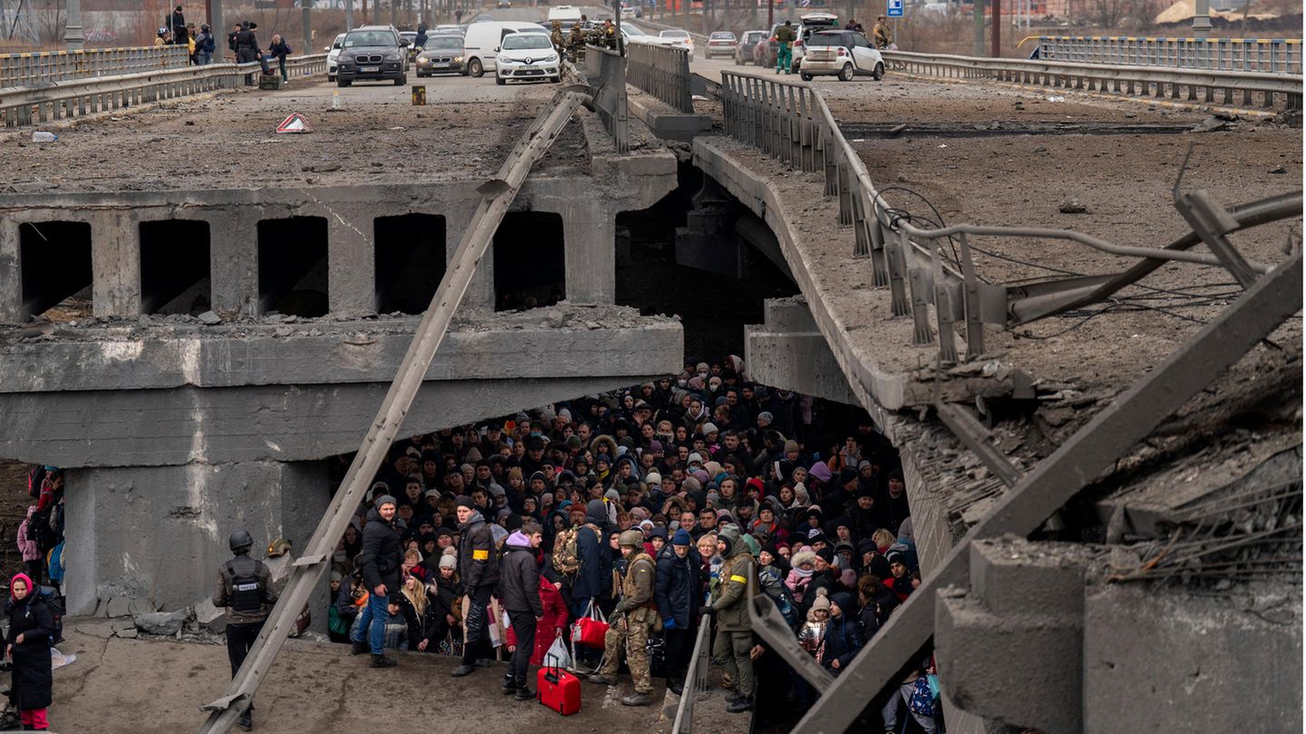 Ukrainer drängen sich unter einer zerstörten Brücke, während sie versuchen, über den Fluss Irpin zu fliehen