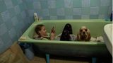 Zlata-Maria sitzt mit ihrem Hund Letti während eines Luftalarms in Lwiw in einer Badewanne