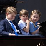 Auch das muss mal sein: Prinz George, aktuell an dritter Stelle der britischen Thronfolge, schneidet eine Grimasse. Seine Schwester Charlotte zeigt mit dem Finger auf ihn und der kleine Louis kaspert ebenfalls herum. So eine Kutschfahrt im Sonnenschein kann auch ganz schön anstrengend werden.