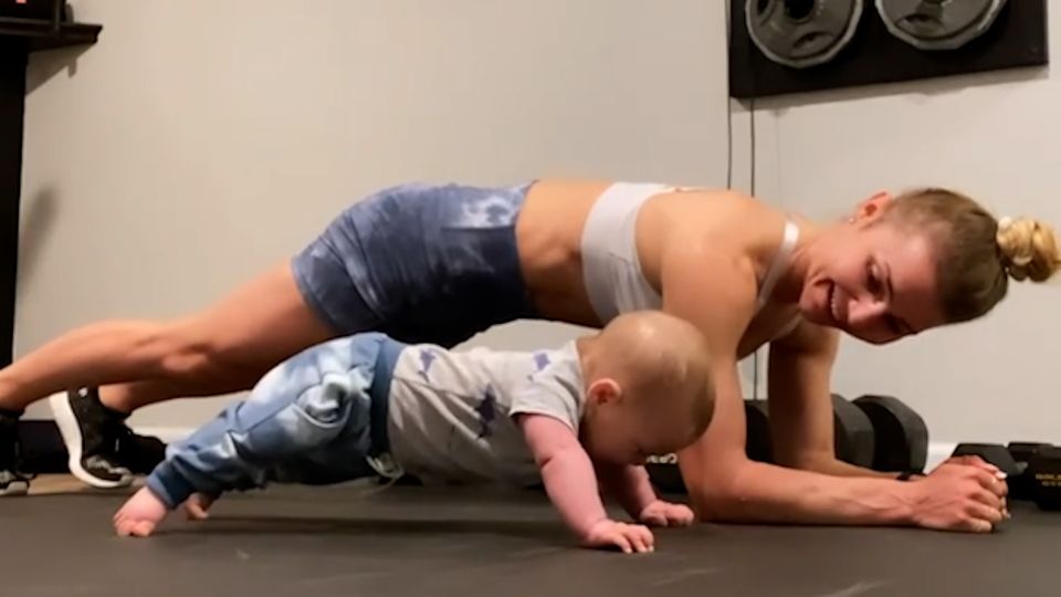 Fitness-Baby plankt mit seiner sportlichen Mama