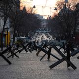 Panzersperren — sogenannte Panzerigel — sichern eine Straße in Odessa, während im Hintergrund die Sonne untergeht