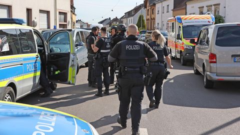 Polizisten stehen nahe des Einsatzortes an der Wilhelmsstraße in Saarbrücken-Klarenthal
