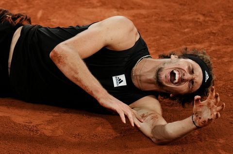 Mit schmerzverzerrtem Gesicht liegt Alexander Zverev auf dem Boden bei den French Open
