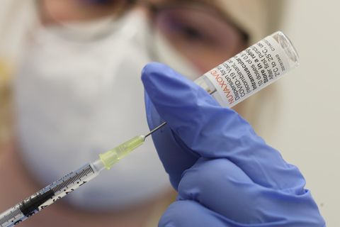 Eine Krankenschwester den Impfstoff Nuvaxovid vom Hersteller Novavax auf eine Spritze auf