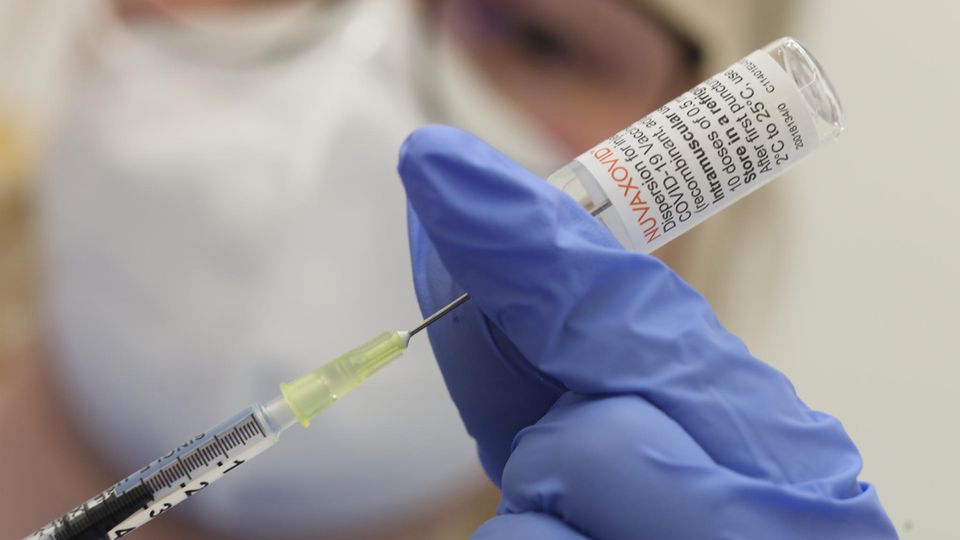 Eine Krankenschwester den Impfstoff Nuvaxovid vom Hersteller Novavax auf eine Spritze auf