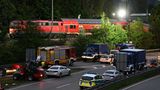 Auf einer mehrspurigen Straße stehen zahlreiche Fahrzeuge von Polizei, Feuerwehr und THW. Dahinter eine Lok und zwei Waggons