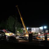 An einer mit Scheinwerfern ausgeleuchteten Unglücksstelle steht ein mobiler Schwerlastkran mit ausgefahrenem Ausleger