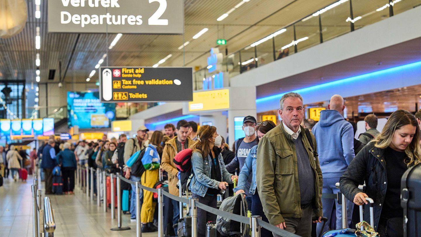 Passagiere in einer Warteschlange am Flughafen Amsterdam
