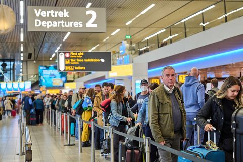 Passagiere in einer Warteschlange am Flughafen Amsterdam
