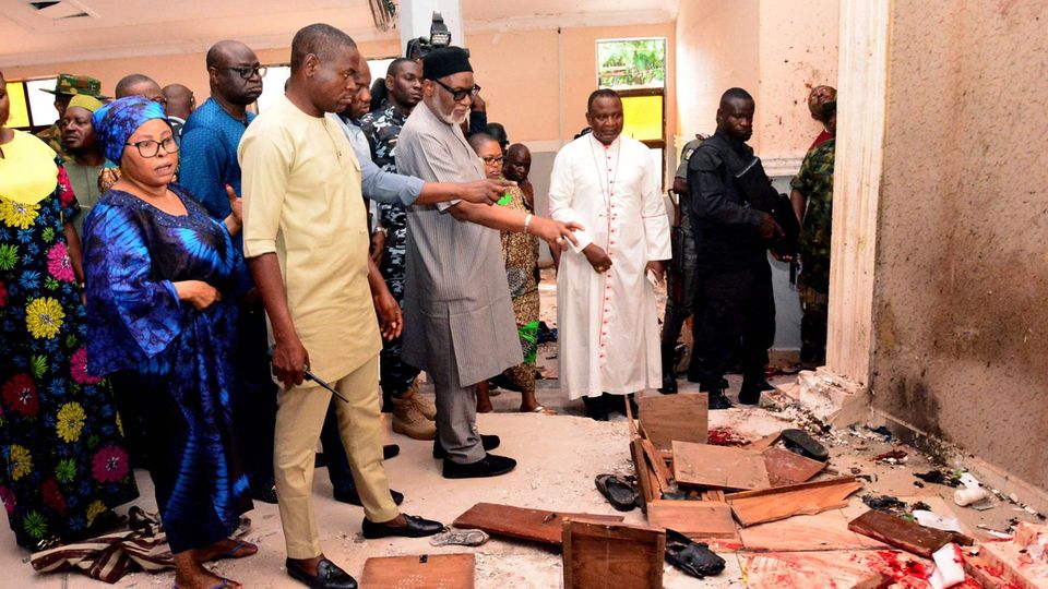 Rotimi Akeredolu (4.v.l.), Gouverneur von Ondo, zeigt sichtlich betroffen auf die Blutflecken in der Kirche, in der Bewaffnete wohl Dutzende Gläubige erschossen