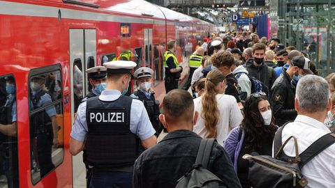 Polizei und Mitarbeiter der Deutschen Bahn weisen Reisenden auf einem überfülltem Bahnsteig im Hauptbahnhof den Weg