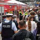 Polizei und Mitarbeiter der Deutschen Bahn weisen Reisenden auf einem überfülltem Bahnsteig im Hauptbahnhof den Weg