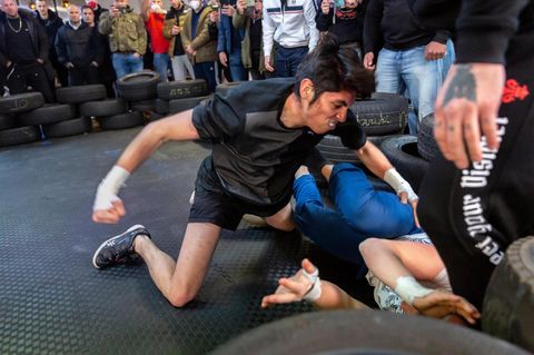 Ein junger Kämpfer schlägt beim Fight Club mit blanken Fäusten auf seinen Gegner ein