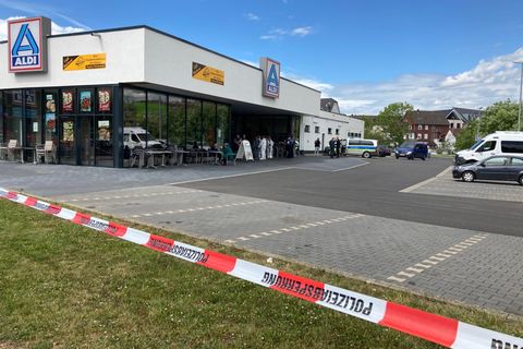 Flatterband hängt vor einem Supermarkt, in dem ein Mann eine Frau und sich selbst tötete