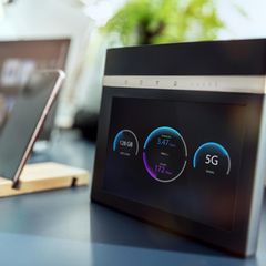 Ein 5G-Router steht auf dem Schreibtisch neben einem Smartphone.
