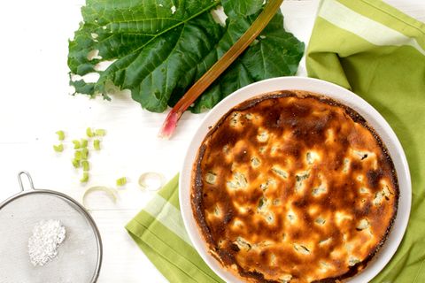 Kuchen und Rhabarber-Blätter, Puderzuckersieb mit Puderzucker auf weißem Holz
