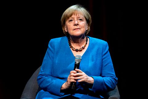 Angela Merkel im blauen Jacket mit Mikro in der Hand