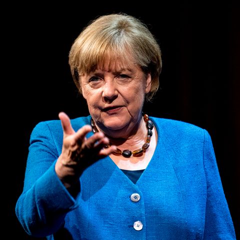 Angela Merkel mit Handzeichen und blauem Jacket