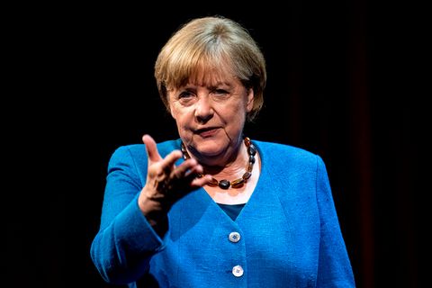 Angela Merkel mit Handzeichen und blauem Jacket