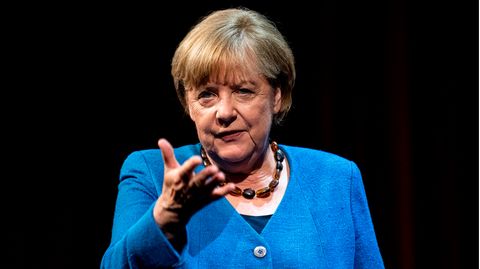 Angela Merkel mit Handzeichen und blauem Jacket