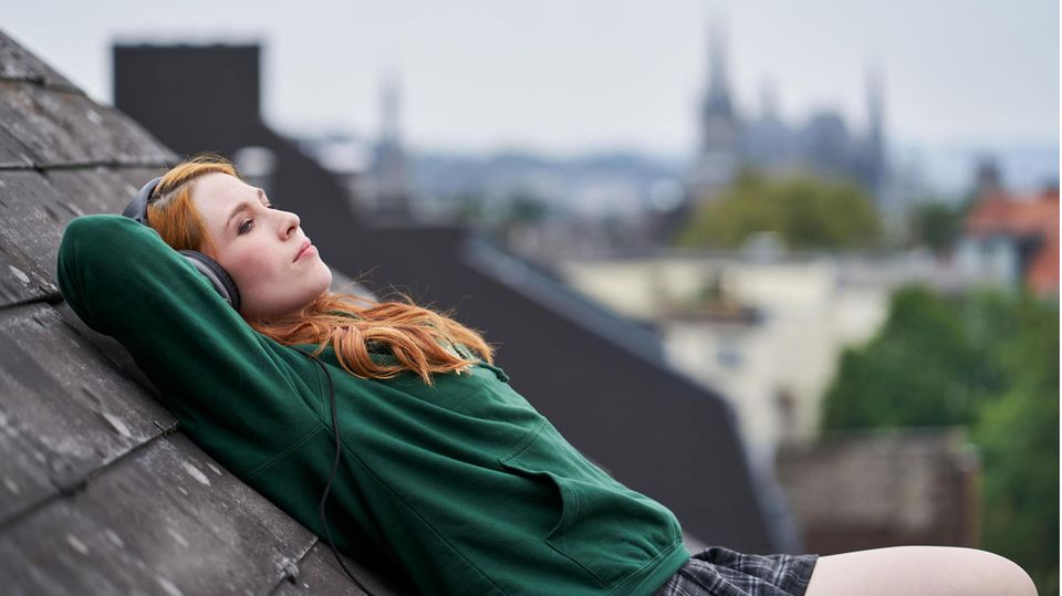 Veronique Kouchev liegt auf einem Dach und hört Musik