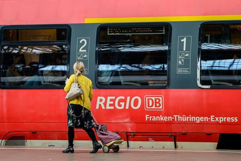 Eine Frau geht an einem Regionalexpress auf dem Hauptbahnhof Leipzig entlang