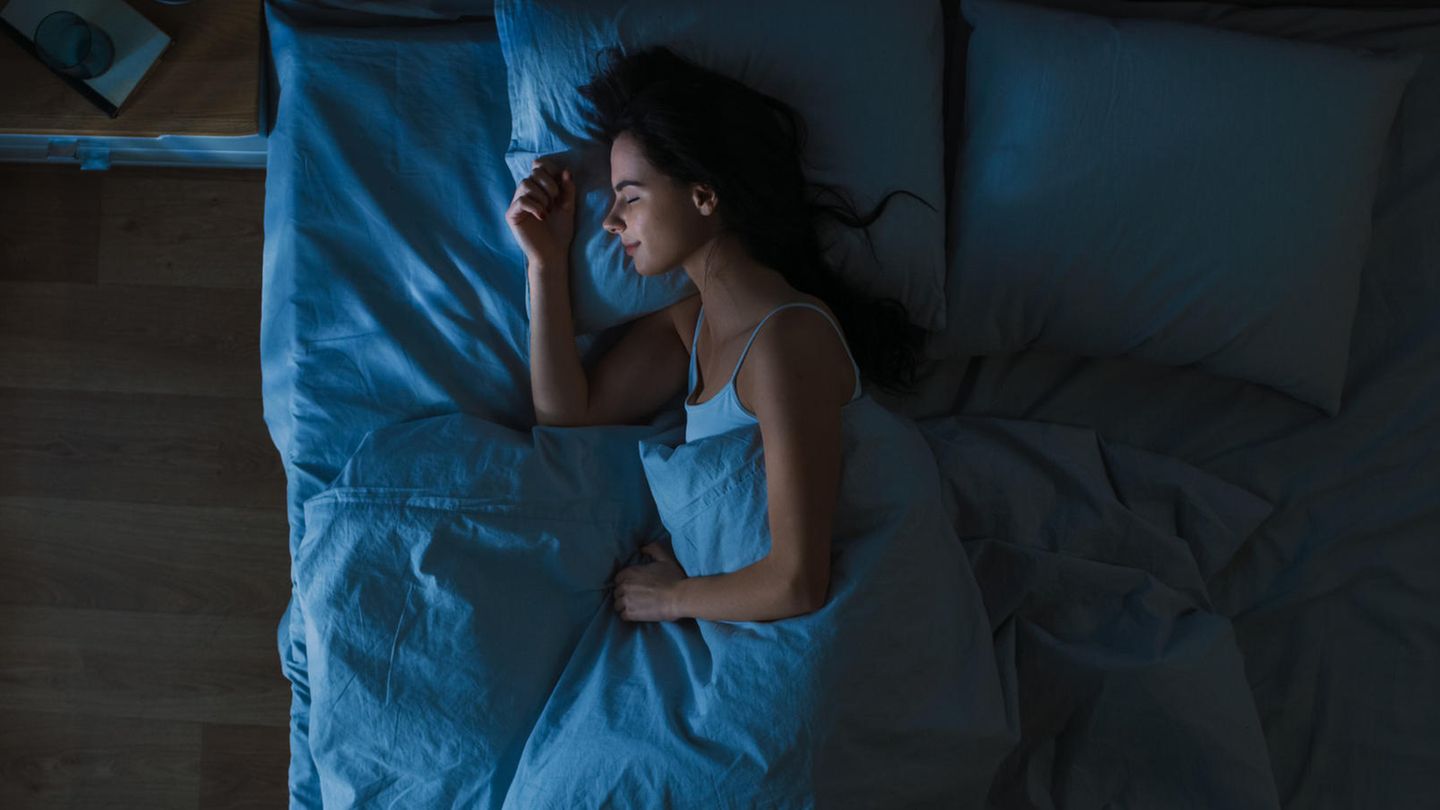 Eine Frau schläft entspannt in ihrem Bett