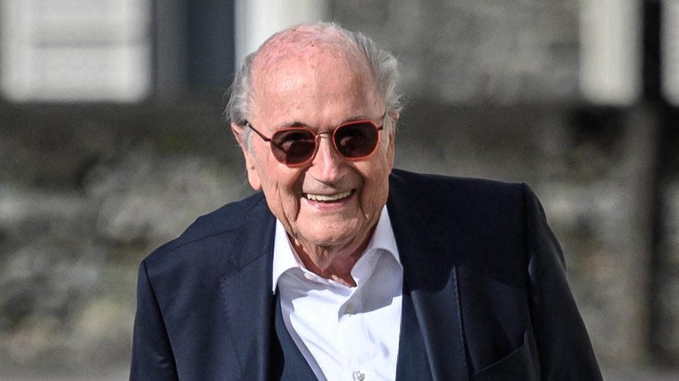 Sepp Blatter lachend auf dem Weg zur Verhandlung, dann bat er wegen gesundheitlicher Probleme um die Verschiebung seiner Aussage