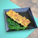 Kartoffel-Zucchini-Auflauf aus Chaniá – Chaniótiko bouréki      Zutaten:  500 g Kartoffeln, 1 kg Zucchini, Salz, 6–7 EL Olivenöl, 2 reife Fleischtomaten, 3 EL fein gehackte Minze, 300 g Feta, zerbröselt, 300 g Mizíthra-Käse (oder Ricotta), 100 g griechischer Joghurt, frisch gemahlener schwarzer Pfeffer      Zubereitung:      Den Backofen auf 180 °C Ober-/Unterhitze vorheizen. Die Kartoffeln schälen. Zucchini und Kartoffeln mit einem Gemüse- hobel in sehr dünne Scheiben schneiden. Die Zucchini salzen und mit den Kartoffelscheiben in eine mit Olivenöl eingefettete Auf-aufform legen. Das Gemüse mit dem Olivenöl beträufeln.  Die Tomaten auf einer Küchenreibe grob reiben, die Schale wegwerfen. Die Minze in eine Schüssel geben. Feta, Mizíthra-Käse und Joghurt hinzufügen, salzen und pfeffern und verrühren. Die Käsemischung auf den Kartoffel- und Zucchinischeiben verteilen. Die Auflaufform mit Alufolie abdecken und alles etwa 1 Stunde im Backofen garen. 15 Minuten vor Ende der Garzeit die Alufolie entfernen.  Das fertige Bouréki etwas abkühlen lassen, in rechteckige Stücke schneiden und servieren.