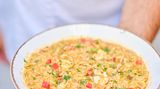 Orzo-Pasta mit Garnelen – Kritharóto me garídes      Zutaten:  1 Stange Lauch, 1 rote Spitzpaprika, 1 Zwiebel, 1 Knoblauchzehe, 4 EL Olivenöl, 50 g Butter, 500 g küchenfertige Garnelen, 500 g Orzo-Pasta, 1,5 l heißer Fischfond, 100 ml Weißwein, 400 g geriebene Tomaten, Salz, frisch gemahlener schwarzer Pfeffer  Zum Servieren  2 EL gehackte Petersilie      Zubereitung:      Den Lauch in dünne Ringe schneiden. Die Paprika würfeln. Zwiebel und Knoblauch fein hacken.  Olivenöl und Butter in einer tiefen Pfanne erhitzen. Zwiebel, Knoblauch, Lauch und Paprika hineingeben und etwas braten. Die Garnelen etwa 2 Minuten mitbraten, dann aus der Pfanne nehmen und warm beiseitestellen.  Anschließend die Orzo-Pasta hinzugeben, die Temperatur erhöhen und alles umrühren. Etwas Fischfond angießen und warten, bis die Nudeln die Flüssigkeit aufgenommen haben. Alles mit dem Weiß- wein ablöschen und die geriebenen Tomaten dazugeben.  Unter ständigem Rühren den restlichen Fischfond nach und nach hinzufügen. Wenn die Nudeln nach etwa 15 Minuten gar sind, die Garnelen unterrühren.  Die Pasta mit Salz und Pfeffer würzen, in tiefen Tellern anrichten, mit Petersilie garnieren und servieren.